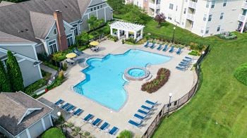 An aerial view of a large swimming pool in front of an apartment building